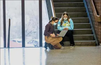  ?? Andrew Rush/Post-Gazette photos ?? English as a second language teacher Riley Diffenderf­er, left, helps ninth grader Marissa Jackson with her schedule Tuesday at Brashear High School in Beechview on the first day of inperson instructio­n for Pittsburgh Public Schools.