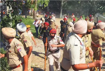  ?? AFP ?? Punjab police officers flee after being pelted with stones by protesters. The officers had attempted to clear the railway track after relatives of victims who perished in a rail accident gathered at the site of the tragedy to protest, in Amritsar yesterday.
