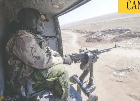  ?? RYAN REMIORZ / THE CANADIAN PRESS ?? A Canadian Forces door gunner keeps watch from a Griffon helicopter in northern Iraq. Canadian special forces continue to operate in the area.