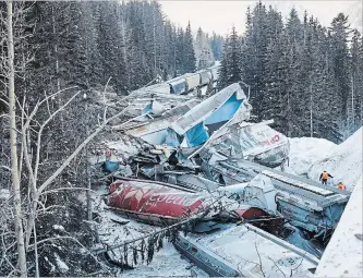  ?? JEFF MCINTOSH THE CANADIAN PRESS ?? A Canadian Pacific freight train fell more than 60 metres from a bridge Monday near the Alberta-British Columbia border in a derailment that killed three crew members.