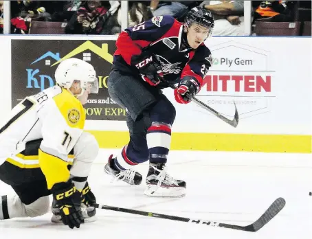  ?? MARK MALONE ?? The Spitfires’ Louis Latta tries to sneak a shot through the Sarnia Sting’s Colton Kammerer during exhibition action Saturday in Sarnia.