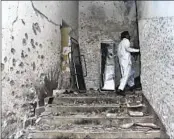  ?? M. NOMAM AP ?? A police officer stands beside the bullet-riddled walls of the Karachi police headquarte­rs Friday.