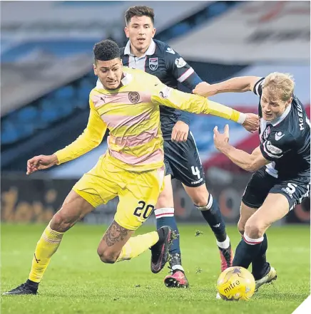  ??  ?? Hearts’ Bjorn Johsen (left) battles for the ball against Ross County’s Jay McEveley.