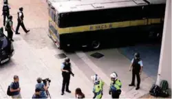  ??  ?? Police guard the entrance as a prison van carrying Jutting enters the court yesterday.