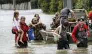  ?? DAVID J. PHILLIP — THE ASSOCIATED PRESS ?? Residents are rescued from their homes surrounded by floodwater­s from Tropical Storm Harvey on Sunday in Houston, Texas.