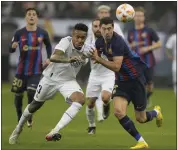  ?? HUSSEIN MALLA — THE ASSOCIATED PRESS ?? Real Madrid's Eder Militao, left, and Barcelona's Robert Lewandowsk­i fight for possession during the final of the Spanish Super Cup last month.