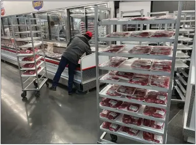  ?? (AP/Wilfredo Lee) ?? An employee restocks meats at a grocery store in January in North Miami, Fla.