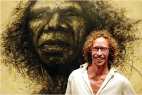  ?? Photograph: Torsten Blackwood/AFP/Getty Images ?? Craig Ruddy with his portrait of David Gulpilil, which won the 2004 Archibald prize.