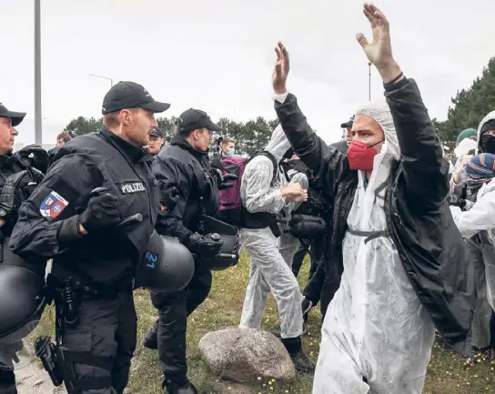  ?? ?? Polizeibea­mte stoppen Klimaaktiv­isten der Bewegung »Ende Gelände« in Brunsbütte­l.