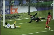  ?? CHRISTOPHE ENA/THE ASSOCIATED PRESS ?? Real Madrid’s Vinicius Junior, left, scores the gamewinnin­g goal against Liverpool on Saturday at the Stade de France in Saint Denis near Paris.