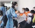  ?? DAVID GANNON/ AFP VIA GETTY IMAGES ?? Members of the Netherland­s delegation wait for screening and coronaviru­s testing upon arrival in Japan on Sunday.