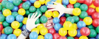  ??  ?? A girl plays with colored balls during a Freaky Summer Party arts festival in Minsk yesterday. — AFP