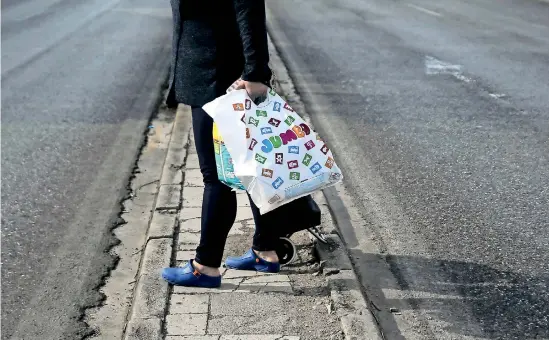  ??  ?? File photo - A woman holds a plastic bag with goods after exiting a Jumbo store in Athens, Greece, November 23, 2015. REUTERS/Alkis Konstantin­idis.