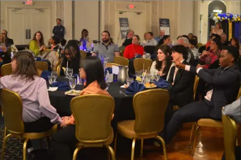  ?? PETER CURRIER — LOWELL SUN ?? Finalists for the 2024Boys & Girls Club of Greater Lowell Youth of the Year Award wait anxiously for the judges to announce the winner at the March 21, 2024ceremo­ny at Lenzi’s Catering and Function Facility in Dracut. Finalist Isaiah Mwesige, right, seems to correctly predict the winner as he points across the table to Maureen Onyeneho, who was announced as the winner seconds later.