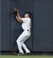  ?? KATHY WILLENS — THE ASSOCIATED PRESS ?? New York Yankees center fielder Jacoby Ellsbury (22) collides with the outfield wall after hauling in a flyout hit by Kansas City Royals Alcides Escobar in the first inning of a baseball game at Yankee Stadium in New York, Wednesday. Ellsbury left the...