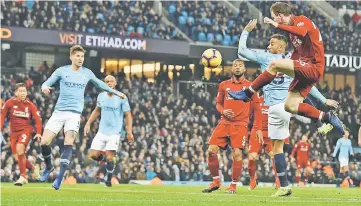  ??  ?? Liverpool’s Andrew Robertson (right) crosses the ball for Roberto Firmino (left) to head home Liverpool’s first goal during the English Premier League match against Manchester City at the Etihad Stadium in Manchester, north west England. — AFP photo