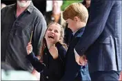 ?? ASHLEY CROWDEN / PA VIA AP ?? Britain’s Princess Charlotte laughs as she conducts a band next to her brother, Prince George, during their visit Saturday to Cardiff Castle in Cardiff, Wales, as members of the Royal Family visit the nations of the UK to celebrate Queen Elizabeth II’s Platinum Jubilee.