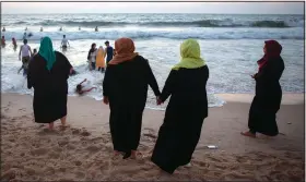  ?? (AP/Khalil Hamra) ?? Palestinia­ns enjoy a summer day July 10 on the beach of Gaza City.