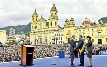  ?? FOTOS JOHNNY HOYOS, AFP Y COLPRENSA ?? El presidente del Congreso, Ernesto Macías, impone la banda presidenci­al a Iván Duque, en el acto de ayer.