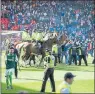  ??  ?? INVASION: Police try to guide fans off the pitch during the cup final.