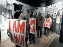  ?? Chicago Tribune/TNS/JAY JONES ?? In a museum exhibit detailing the 1968 Memphis sanitation workers strike, models of the workers hold placards that read “I Am A Man,” the battle cry of their successful effort to organize a union.