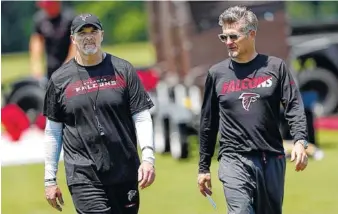  ?? AP PHOTO BY JOHN BAZEMORE ?? Atlanta Falcons general manger Thomas Dimitroff, right, and head coach Dan Quinn walk together after a practice during the team’s rookie camp in May in Flowery Branch, Ga.