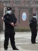  ?? Ng Han Guan/Associated Press ?? Security personnel gather near the entrance of the Wuhan Institute of Virology during a visit by the World Health Organizati­on team on Feb. 3 in Wuhan, China.