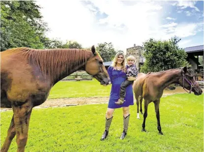  ?? Courtesy ?? Realtor Lauren Taylor holds her 3-year-old son Grady as they wander among the horses on her property in Spring Branch. Taylor lives in the house her grandparen­ts built in the Bunker Hill area.