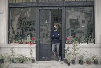  ?? NATACHA PISARENKO/AP ?? Tango dancer and musician Nicolas Ponce outside the plant shop he started after the COVID-19 pandemic lockdown closed dance venues in Buenos Aires, Argentina.