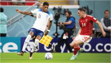  ?? — Photo by Getty Images ?? DANGER MAN . . . England striker Marcus Rashford (left) takes on Wales’ Conor Roberts during their FIFA World Cup match on Tuesday night.