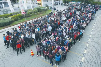  ?? (Darren Whiteside/Reuters) ?? RECENT GRADUATES wait for the opening of a job fair held inside a shopping mall yesterday in Bekasi, east of Jakarta, Indonesia.