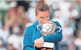  ??  ?? Simona Halep hugs the trophy after her women’s final victory against Sloane Stephens at the French Open on Sunday in Paris. SUSAN MULLANE/USA TODAY SPORTS