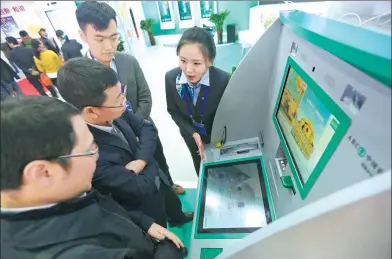  ?? A QING / FOR CHINA DAILY ?? Vistors check out the booth of Agricultur­al Bank of China at the 12th Internatio­nal Financial Expo in Beijing.