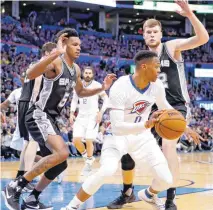  ?? [PHOTO BY NATE BILLINGS, THE OKLAHOMAN] ?? Russell Westbrook dribbles away from San Antonio’s Dejounte Murray, left, and Davis Bertans during Thursday’s game between the Oklahoma City Thunder and the San Antonio Spurs at Chesapeake Energy Arena. Oklahoma City won 102-92.