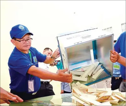  ?? HENG CHIVOAN ?? Officials empty ballot boxes at a polling station in Yukunthor High School in Phnom Penh on Sunday.