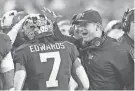  ?? MELANIE MAXWELL/DETROIT FREE PRESS ?? Michigan coach Jim Harbaugh celebrates with running back Donovan Edwards after his touchdown in the first quarter of the College Football Playoff national championsh­ip game against Washington at NRG Stadium in Houston on January 8.