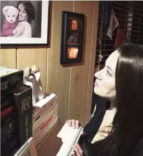  ?? JOSHUA REPLOGLE AP file ?? Casey Anthony in a 2017 photo looks up at a portrait of her with her daughter, Caylee, in her West Palm Beach bedroom.