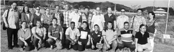  ??  ?? Gerawat (centre) posing with the SK Bario staff and visitors at the site of SK Bario which was burnt in 2016.