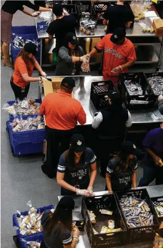  ?? Godofredo A. Vasquez / Houston Chronicle ?? Astros legend Jose Cruz, top right, and other volunteers help pack lunch bags at the Houston Food Bank on Friday. The Astros have partnered with the Houston Food Bank since 2014, hosting monthly volunteer opportunit­ies for staff and players.