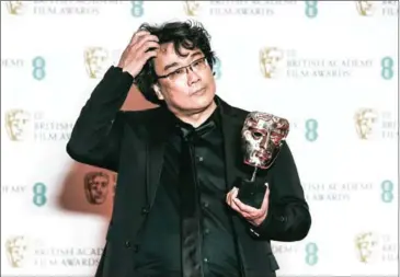  ?? AFP ?? South Korean director Bong Joon-ho poses with their award for a Film Not In The English Language for ‘Parasite’ at the Bafta British Academy Film Awards at the Royal Albert Hall in London on Sunday.