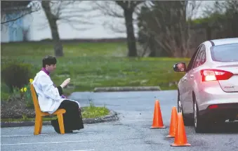  ?? JONATHAN NEWTON/THE WASHINGTON POST ?? Rev. Scott Holmer hears confession­s outside at St. Edward the Confessor Catholic church in Bowie, Md. Members stay a healthy distance away.