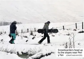  ?? JONATHAN MYERS ?? Snowboarde­rs head up to the slopes near Pen y Fan