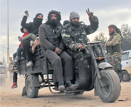  ?? AFP ?? Aus einer Kampfzone in Aleppo entkommene Syrer feiern ihre Ankunft in angrenzend­en Rebellenge­bieten.