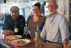  ?? KRISTI GARABRANDT — THE NEWS-HERALD ?? Peter Naer, Meghan Hammond and Pat Hammond, owners of the New Erie Street Station, opening soon in Downtown Willoughby display some of the wines and pasta dishes customers can find on the menu.