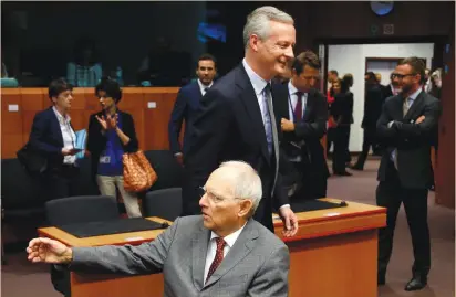  ?? (Francois Lenoir/Reuters) ?? FRENCH ECONOMY MINISTER Bruno Le Maire (center) and German Finance Minister Wolfgang Schaeuble (seated) attend a meeting of euro-zone finance ministers yesterday in Brussels. Surprising­ly strong data on German exports in May lifted German equities and...
