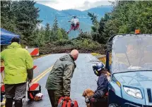  ?? Willis Walunga/Associated Press ?? A helicopter arrives on the Zimovia Highway where ground teams search for three missing people Wednesday in Wrangell, Alaska.