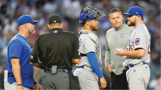  ?? FRANK FRANKLIN II/AP ?? A trainer checks on Cubs left-hander Wade Miley (right) on Friday. Miley was put on the 15-day injured list Saturday with a strained left shoulder.