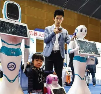  ?? Photo: Xinhua ?? This November 19, 2017 photo shows children interact with robots during the 19th China Hi-tech Fair in Shenzhen, south China’s Guangdong Province.
