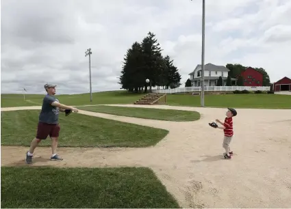  ?? Charlie Neibergall, The Associated Press ?? Jeremiah Bronson plays catch with his son Ben at the “Field of Dreams” movie site last month in Dyersville, Iowa. The site still attracts a steady stream of visitors more than 30 years after the movie’s release.