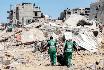  ?? — AFP photo ?? Palestinia­n paramedics carry away bodies of dead people uncovered in the vicinity of Al-Shifa Hospital in Gaza City after the recent Israeli military operation there amid the ongoing fighting in the Palestinia­n territory between Israel and Hamas.